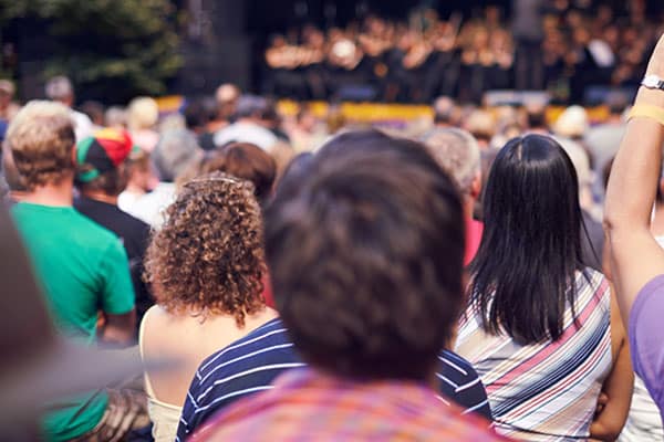 Shot of a person in the crowd holding a camera to photograph a classical concert